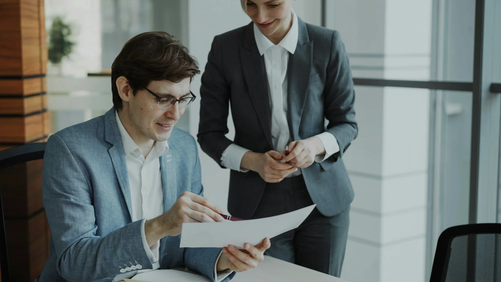 Two advisers reviewing information around a table